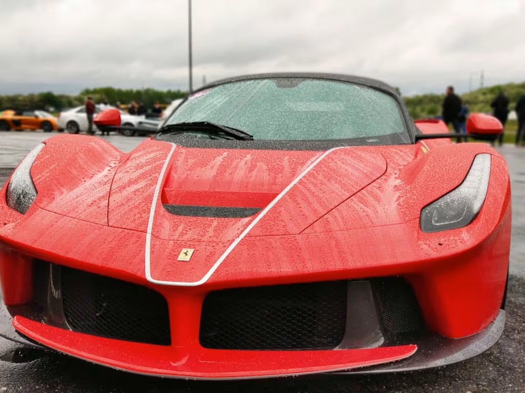 Rød Ferrari laferrari aperta sportsvogn parkeret udenfor på en regnvejrsdag.