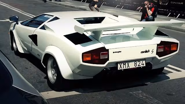 Hvid sportsvogn Lamborghini Countach set bagfra parkeret på en gade.